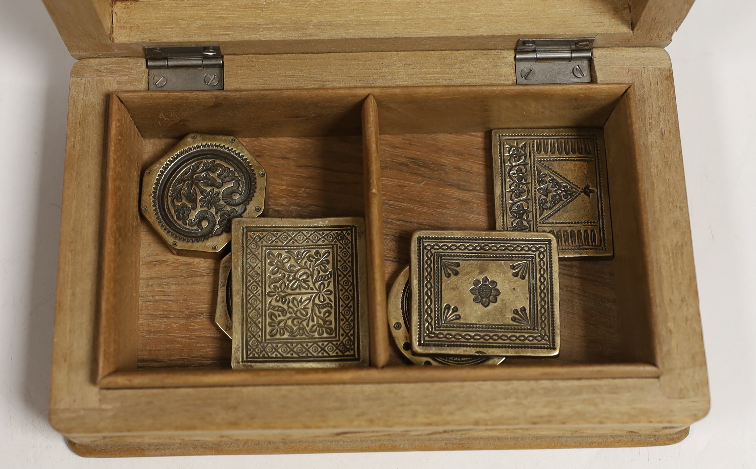 A group of Indian bronze sweet moulds, contained in a carved teak box